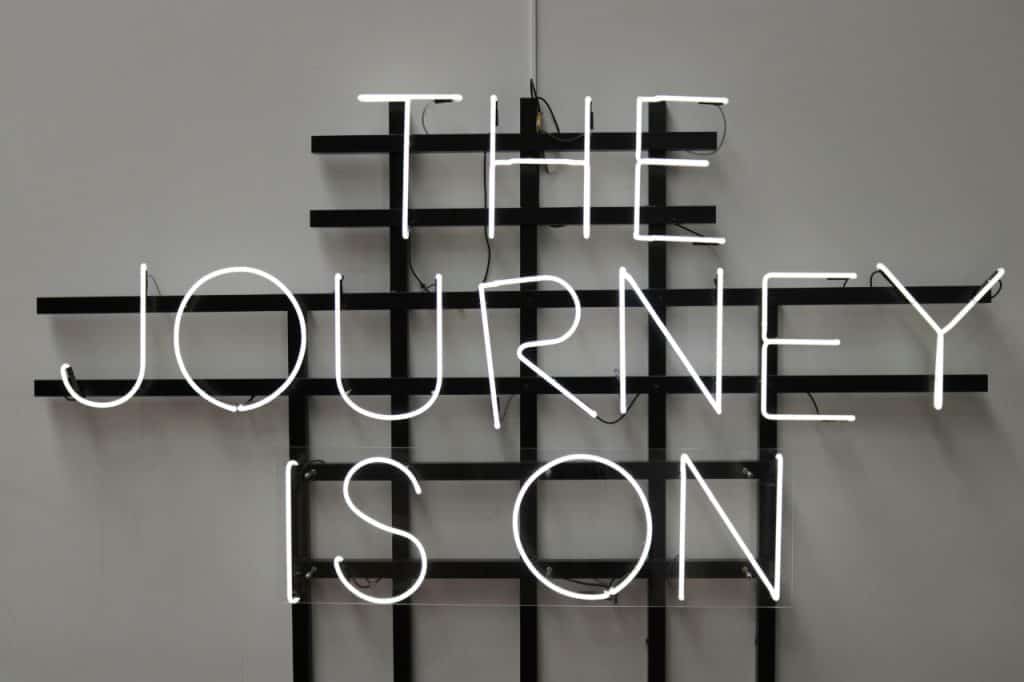 The Journey is On neon sign hanging on wall